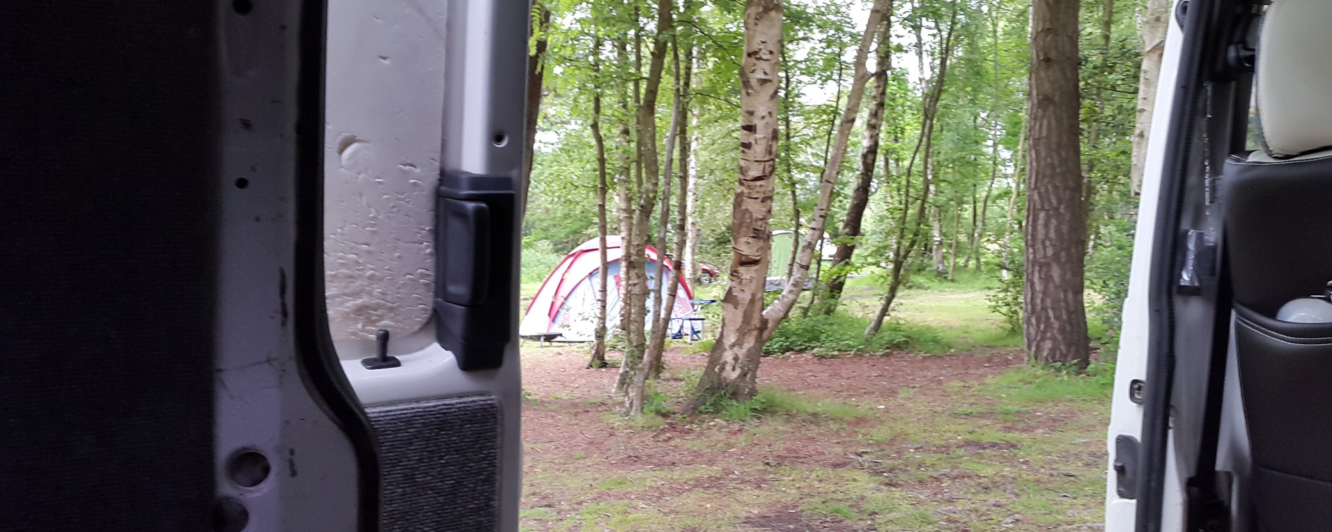 View out of campervan side door across Burnbake Campsite
